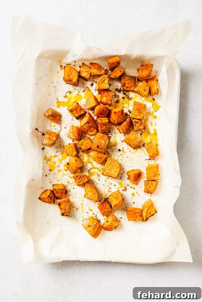 cooked diced sweet potato on a baking sheet.