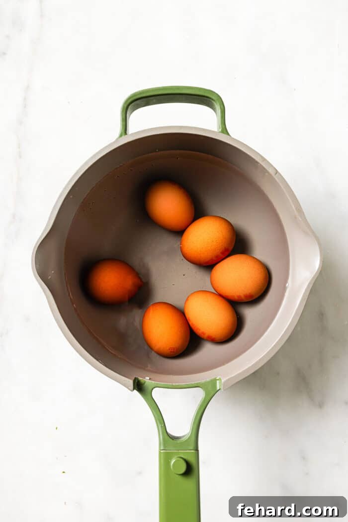 Six hard-boiled eggs in a small green pot. 