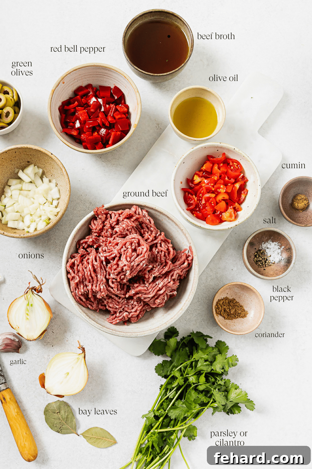 Pre-measured Picadillo ingredients neatly arranged in small bowls with clear text labels, showcasing fresh produce and spices.
