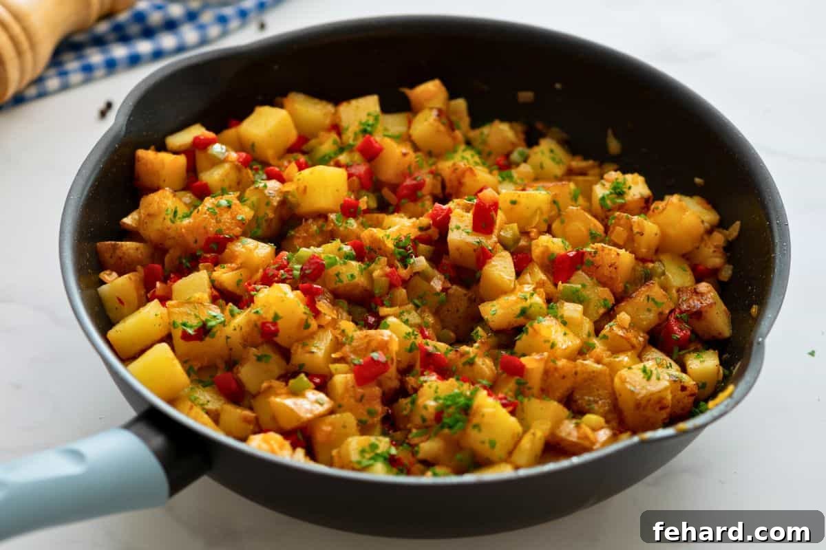 Fully cooked Potatoes O'Brien in a large skillet, vibrant with peppers and onions, garnished with fresh chopped parsley.