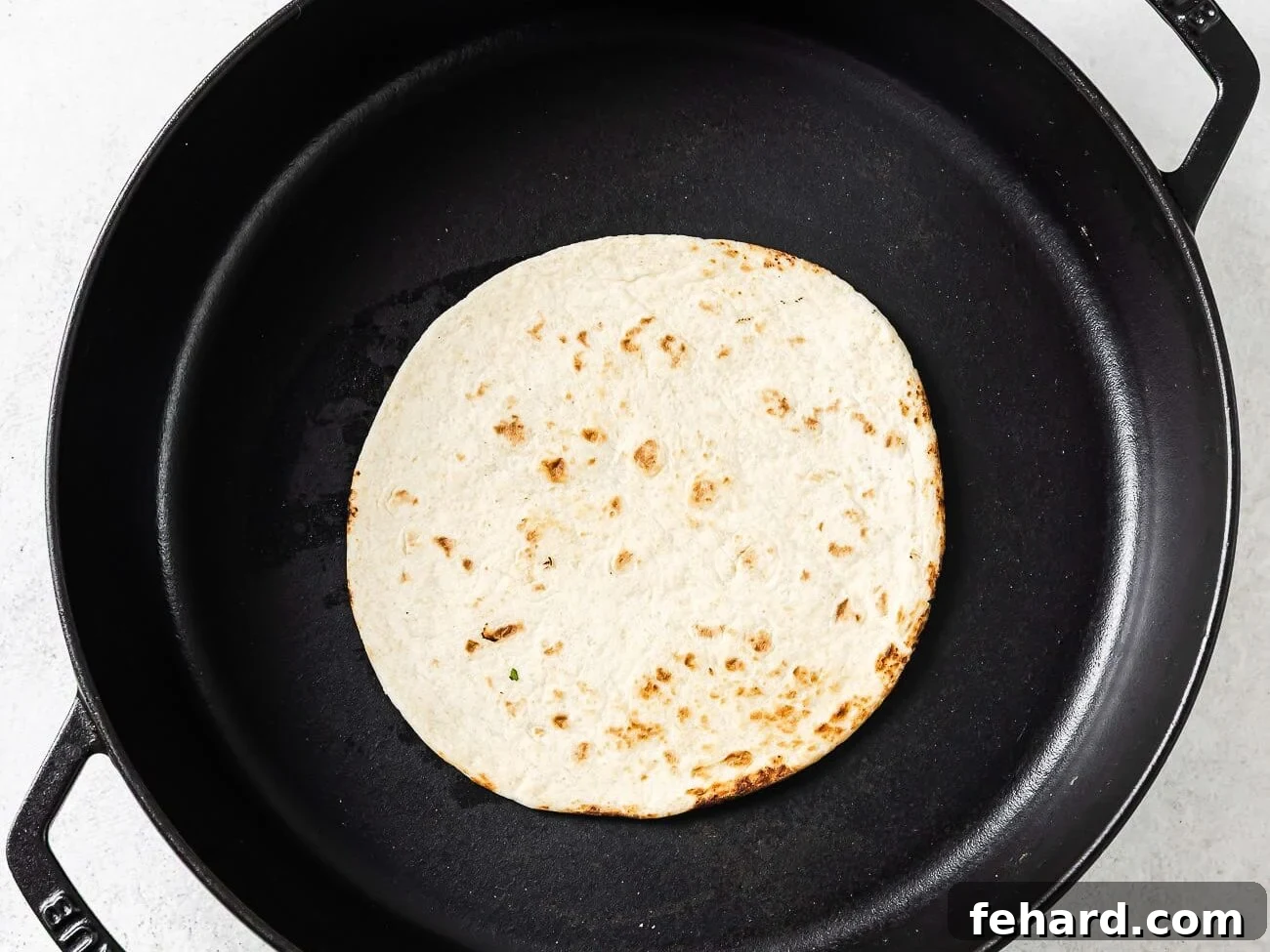 Baja Shrimp Fiesta 6 A single flour tortilla is warming in a black cast-iron skillet.