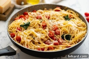 Quick White Bean Pasta with Burst Tomatoes and Fresh Spinach 9 Large skillet with pasta, white beans, tomatoes, and spinach topped with parmesan.