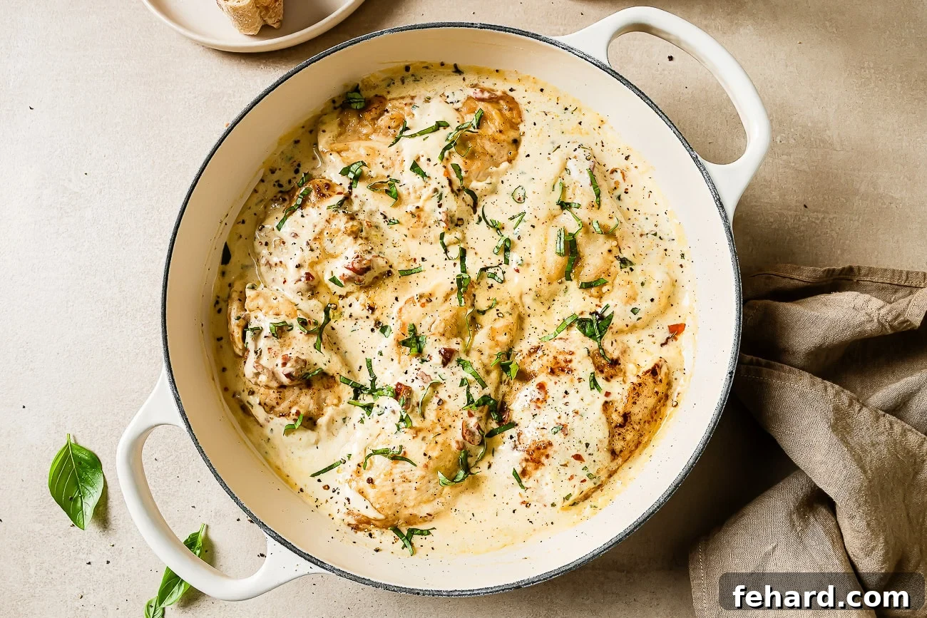 An inviting overhead shot of Marry Me Chicken beautifully garnished with fresh basil, served alongside a slice of crusty bread, ready to be enjoyed.