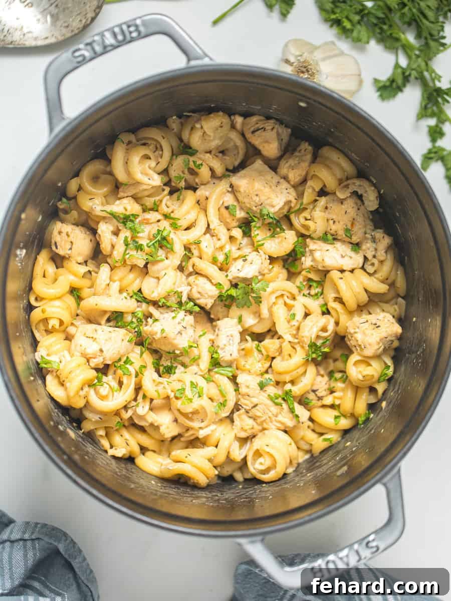 Delicious One-Pan Garlic Parmesan Chicken Pasta Creamy Parmesan Chicken Pasta in a large stock pan, garnished with fresh parsley and ready to be served.