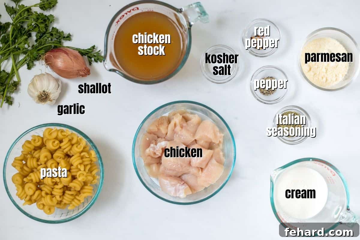 Key Ingredients for Creamy Garlic Parmesan Chicken Pasta All the fresh ingredients for creamy garlic parmesan pasta with chicken, neatly arranged on a rustic wooden surface.