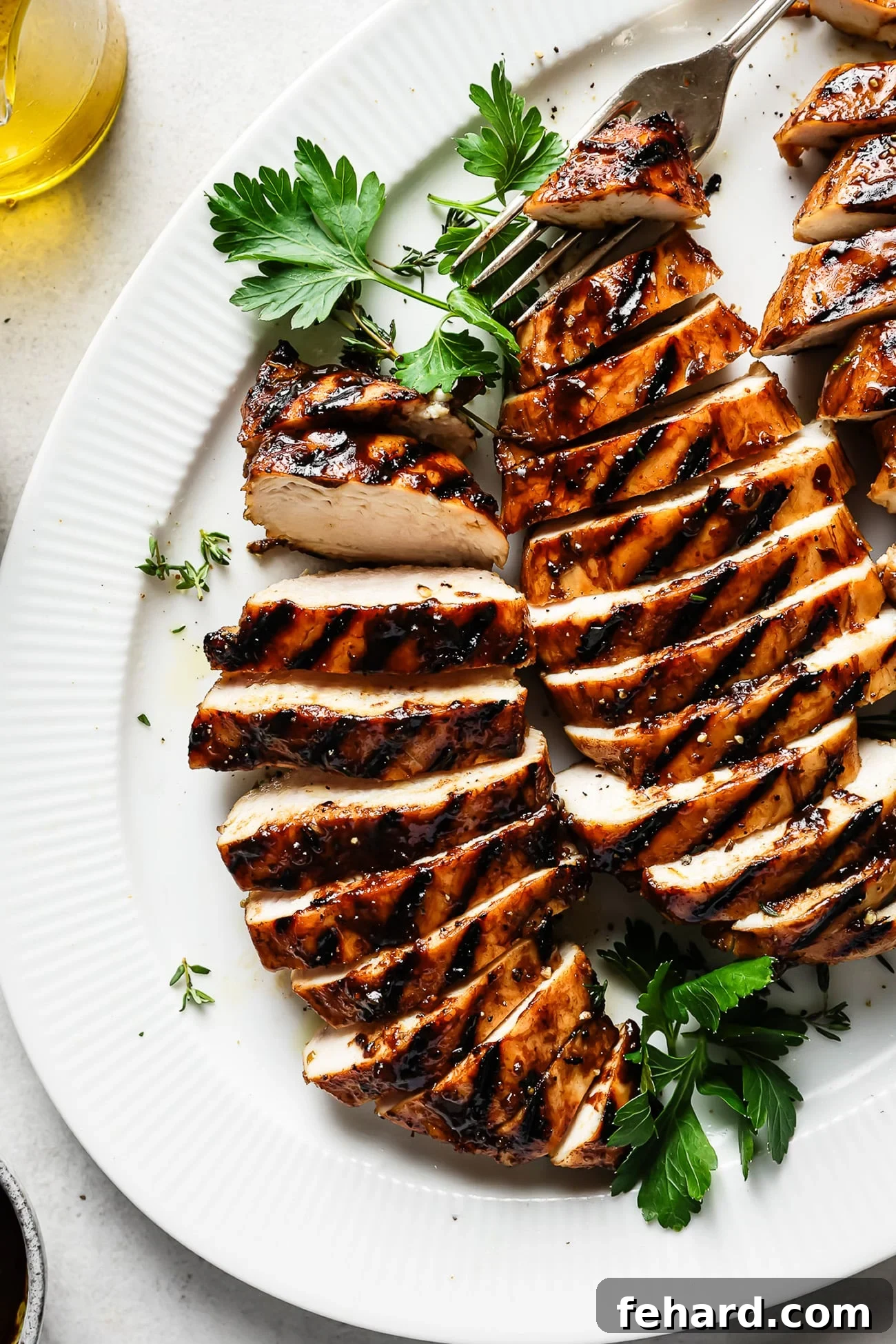 Signature Balsamic Chicken Marinade 2 Perfectly grilled balsamic chicken served on a white plate, garnished with fresh herbs.