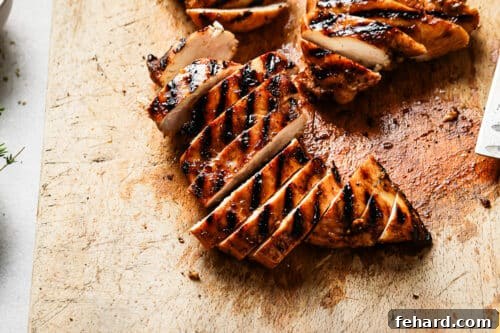 Grilled chicken breast on a wooden board.