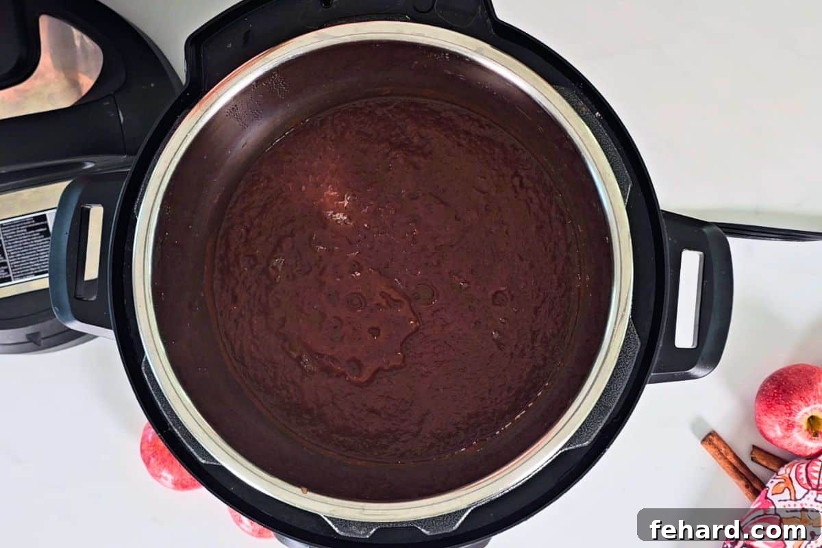 Apple Butter Homemade Pressure-cooked apple butter after being thickened, showing its rich, dark color and smooth texture in the inner pot.