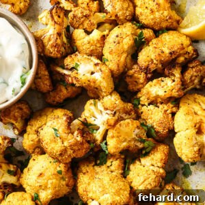 Overhead view of crispy air-fried cauliflower on a white plate.