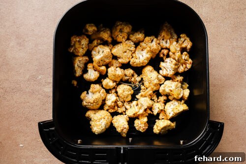 cauliflower florets in a air fryer basket