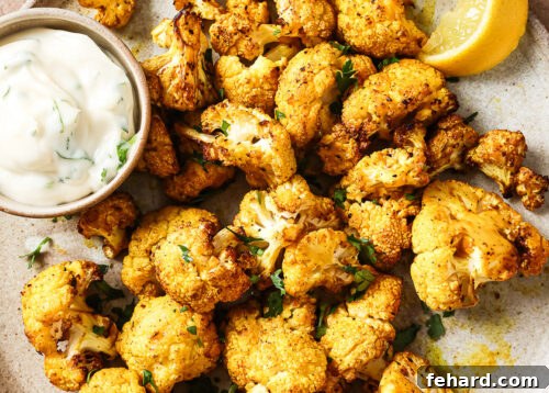 Overhead view of crispy air-fried cauliflower on a white plate.