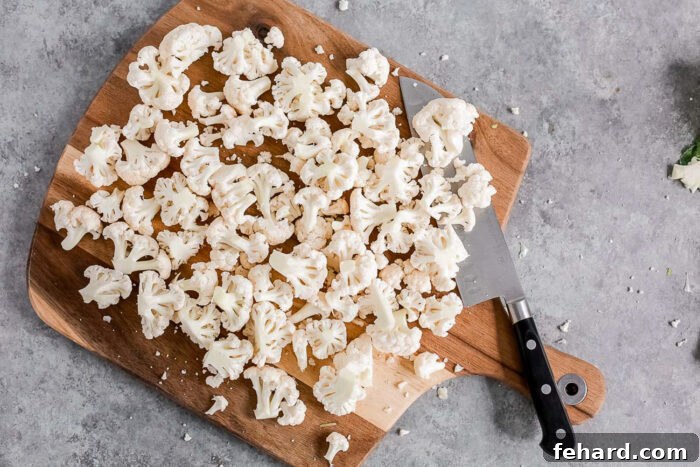Cauliflower florets on a wooden board.