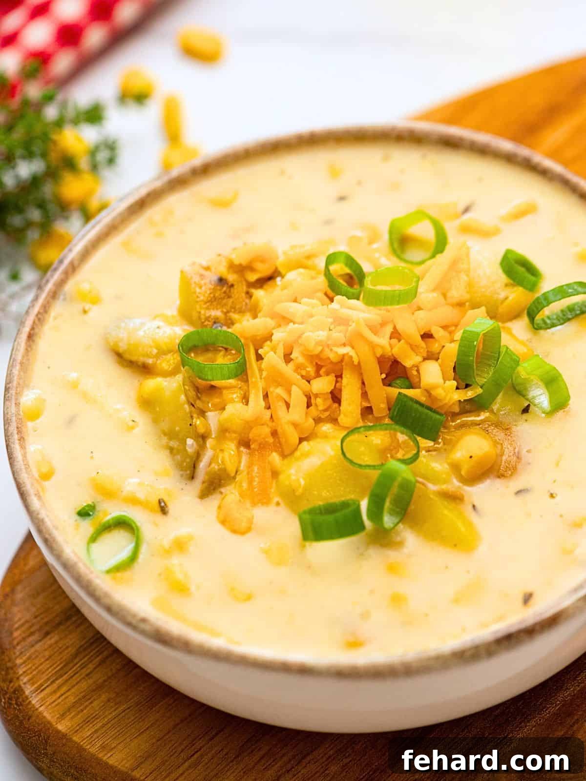 Instant Pot Potato Corn Chowder: Creamy Comfort in Minutes A steaming bowl of creamy Instant Pot potato corn chowder, garnished generously with shredded cheddar cheese and vibrant sliced green onions, promising a delightful and comforting meal.