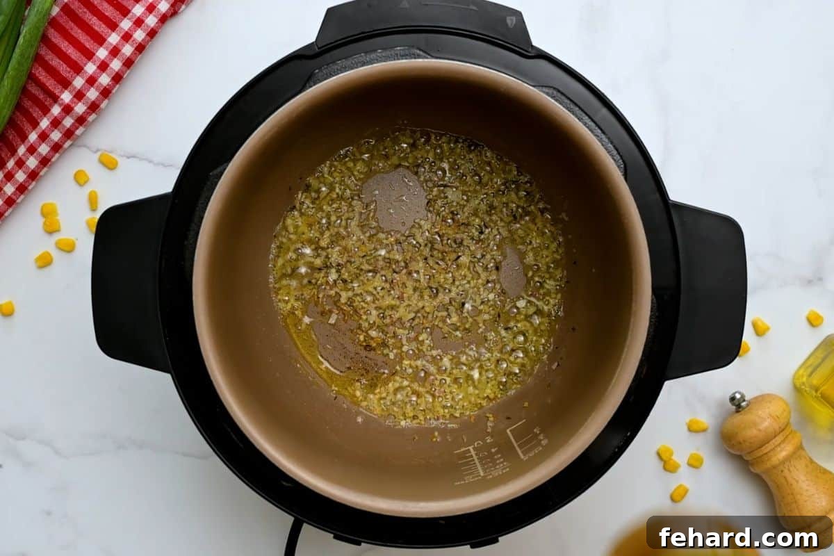Sautéing Shallots and Thyme for Instant Pot Chowder Minced shallot and dried thyme being sautéed in a mixture of butter and olive oil inside the Instant Pot's inner pot, forming the aromatic base for the potato corn chowder.