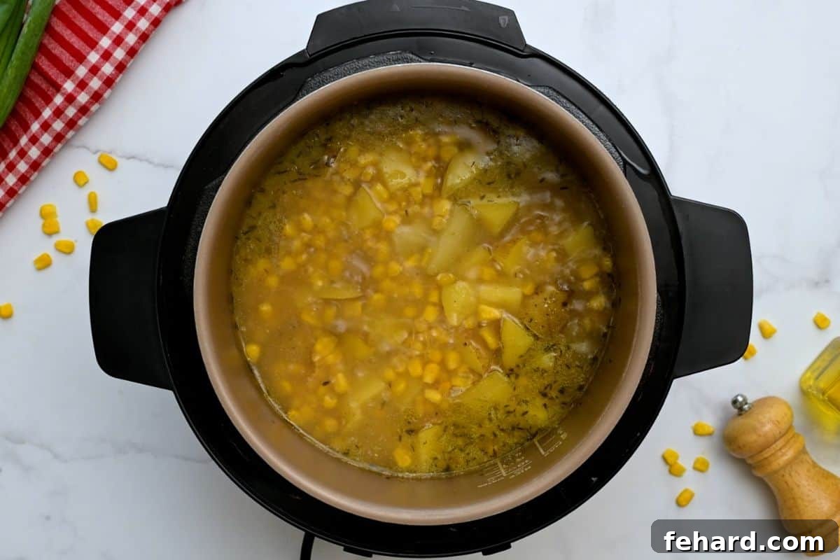 Instant Pot Chowder After Pressure Cooking The Instant Pot, with its lid removed, reveals perfectly cooked potato corn chowder after the pressure cooking cycle and natural release, before the final creamy thickener is added.