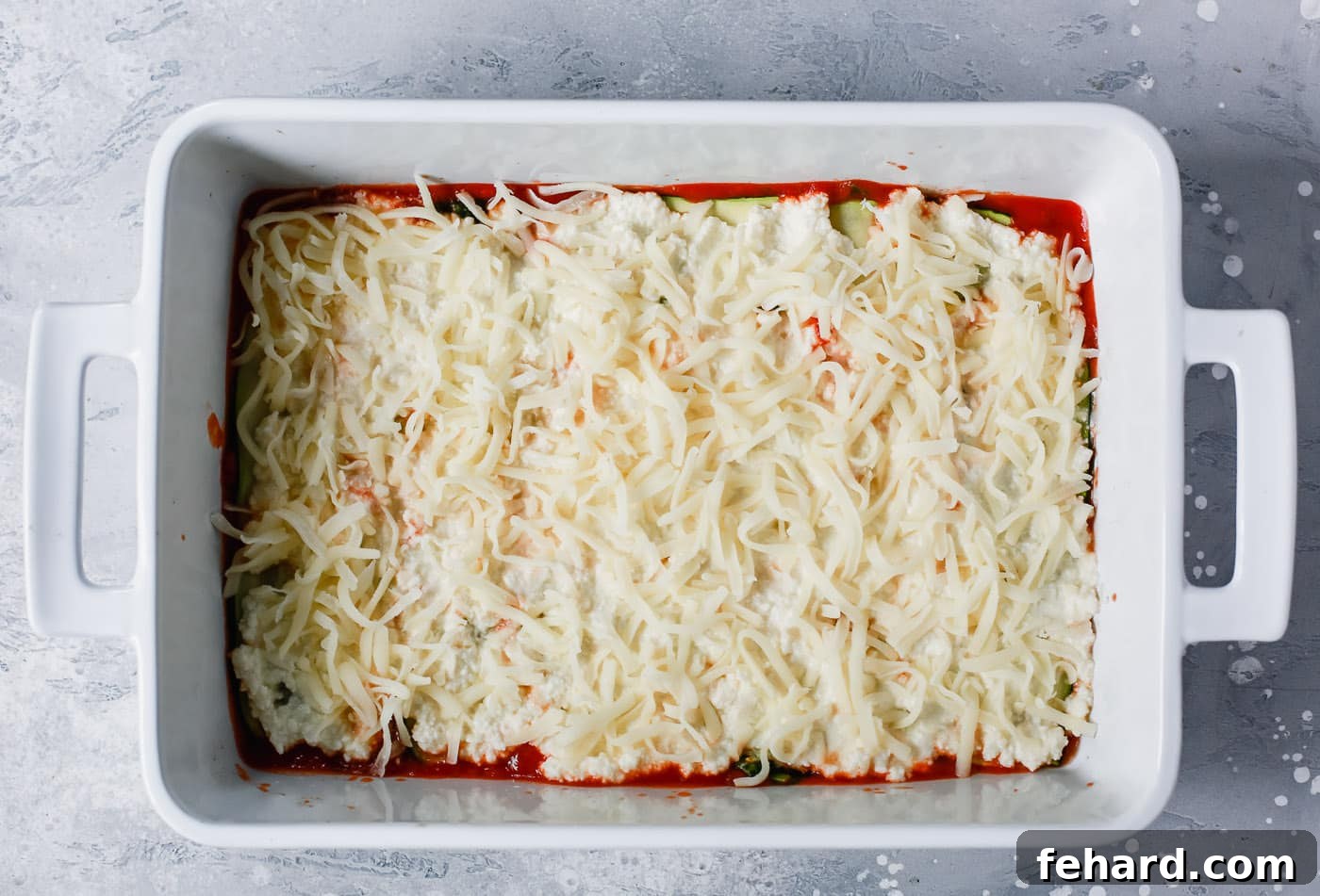 Zucchini Ribbon Bake 6 overhead view of a white casserole containing tomato sauce, zucchini noodles and mozzarella cheese