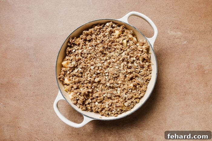 Warm Spiced Gluten Free Apple Crumble 7 Apple crisp in a white skillet ready to be baked in the oven for a warm and cozy dessert.
