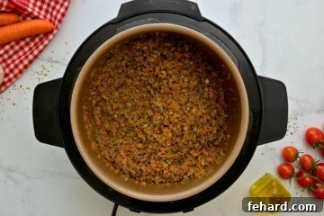 Rich & Rapid Instant Pot Bolognese 6 Browned meat, sausage, and sofrito inside inner pot for base of Bolognese Sauce.