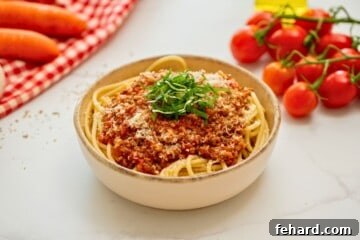 Rich & Rapid Instant Pot Bolognese 9 Instant Pot Bolognese Sauce served over cooked spaghetti noodles topped with parmesan and basil ribbons.