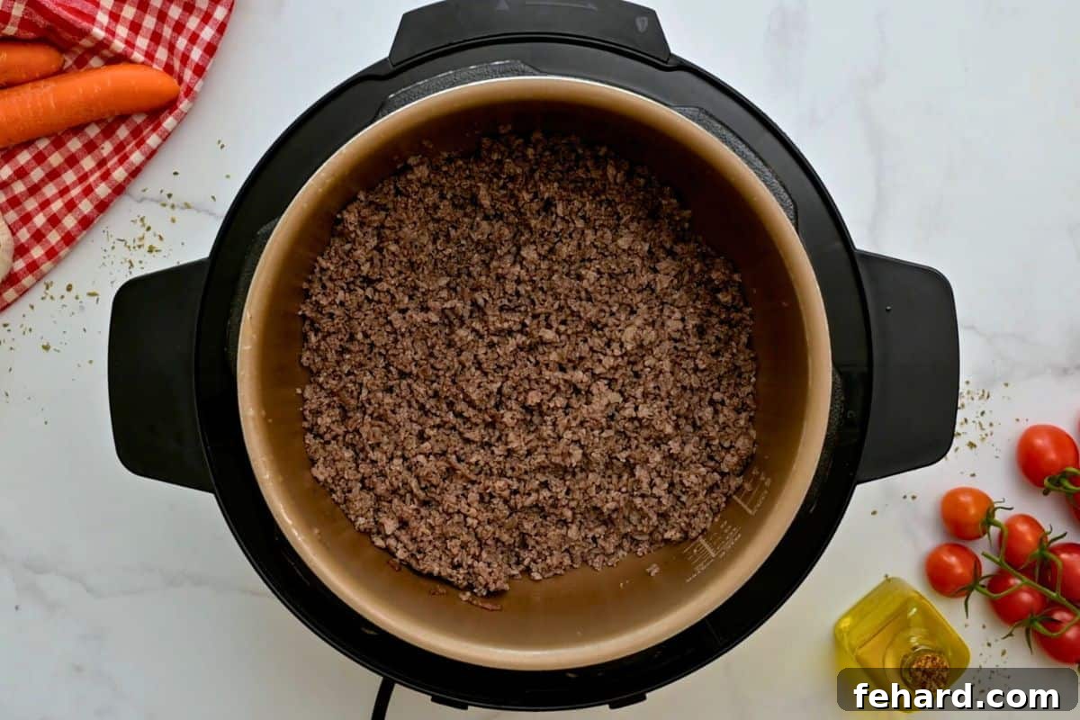 Recipe Instant Pot Bolognese Browned sausage and beef inside inner pot for base of Bolognese Sauce.