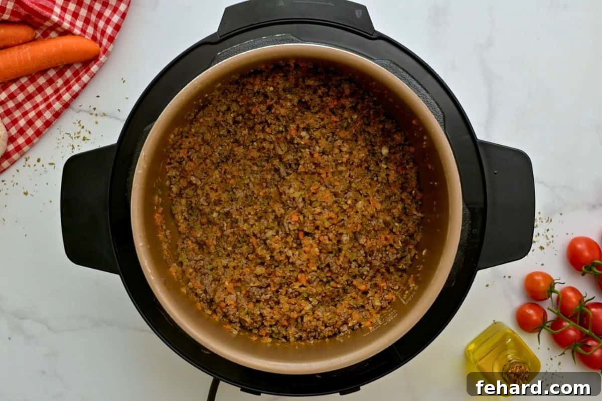 Bolognese Sauce Instant Pot Browned meat, sausage, and sofrito inside inner pot for base of Bolognese Sauce.