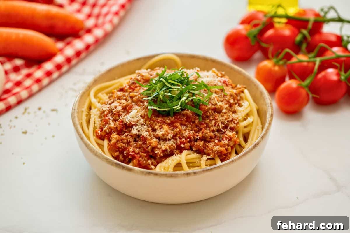 Recipe Instant Pot Bolognese Sauce Instant Pot Bolognese Sauce served over cooked spaghetti noodles topped with parmesan and basil ribbons.