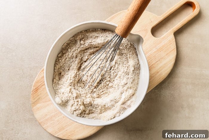 Dry baking ingredients inside a mixing bowl, ready to be combined, including almond flour, tapioca flour, baking soda, and cinnamon.