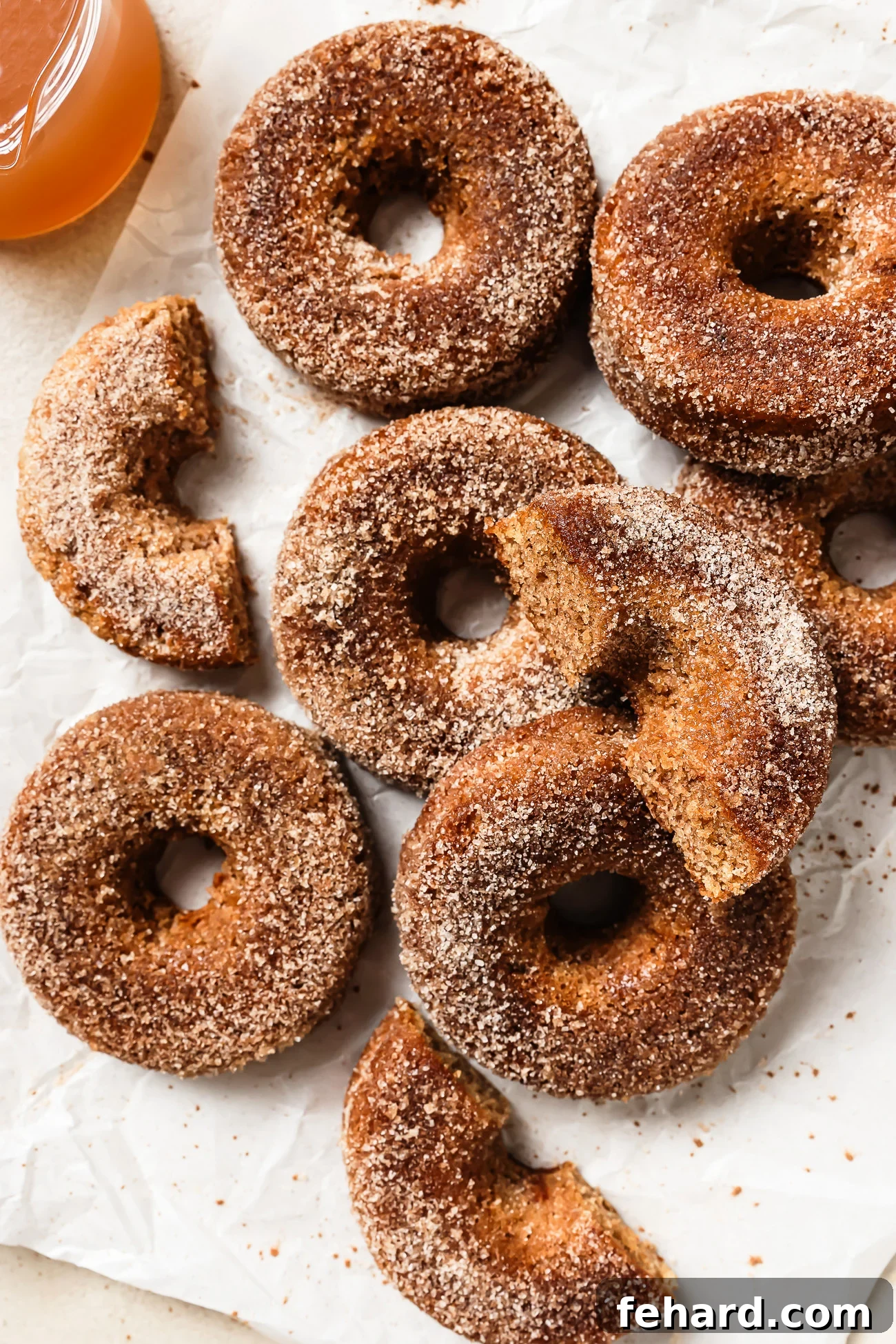 A tray of beautifully coated gluten-free apple cider donuts on a countertop, ready to be enjoyed.