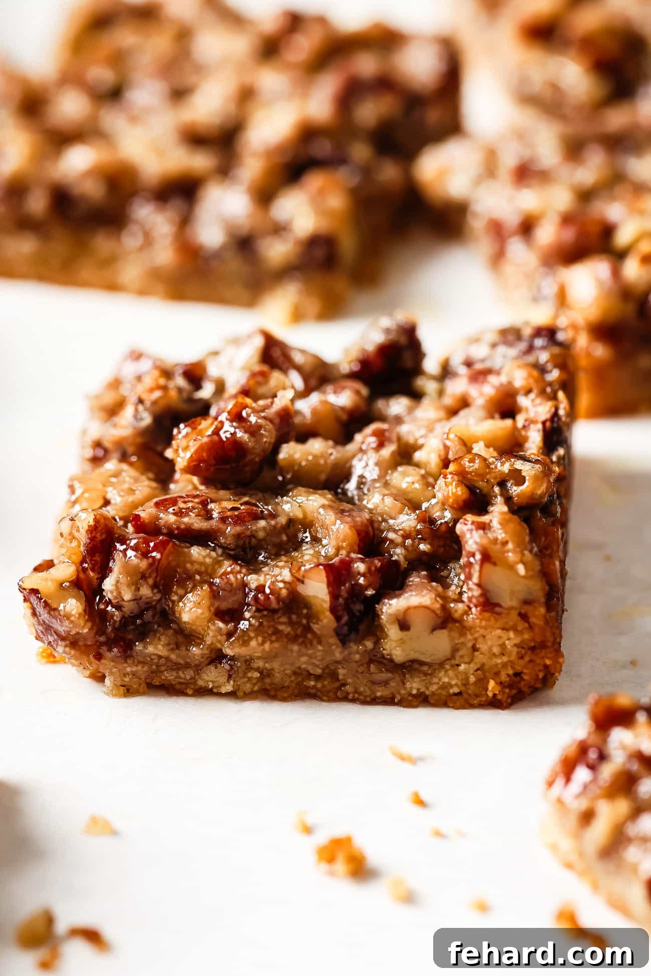 Irresistible Gluten-Free Pecan Bars 9 Close up of a single gluten-free pecan pie bar on a countertop, showcasing its layers and rich topping.