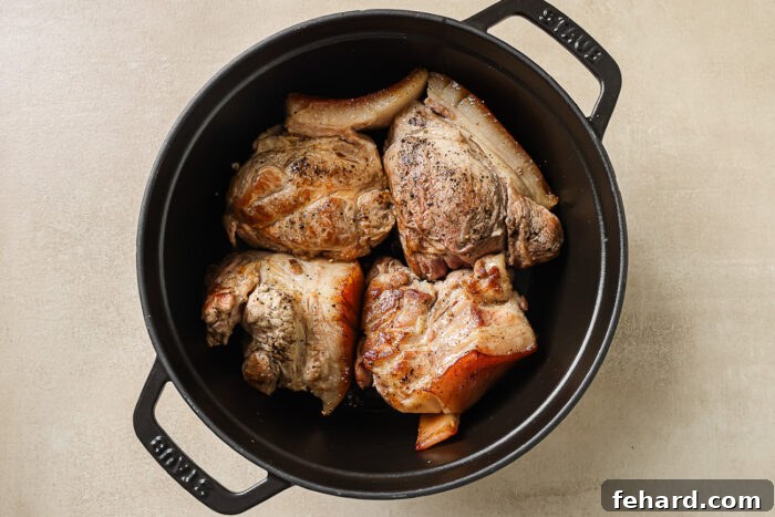 pork shoulder pieces in a black Dutch oven pot. 