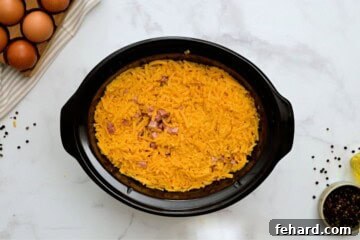 Lazy Day Breakfast Bake 5 Hash browns, cheese, ham, peppers, and eggs layered in large crockpot to make crockpot breakfast casserole.