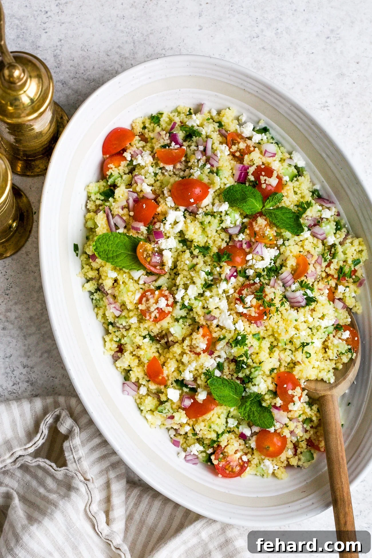 closeup of couscous salad in a white bowl.
