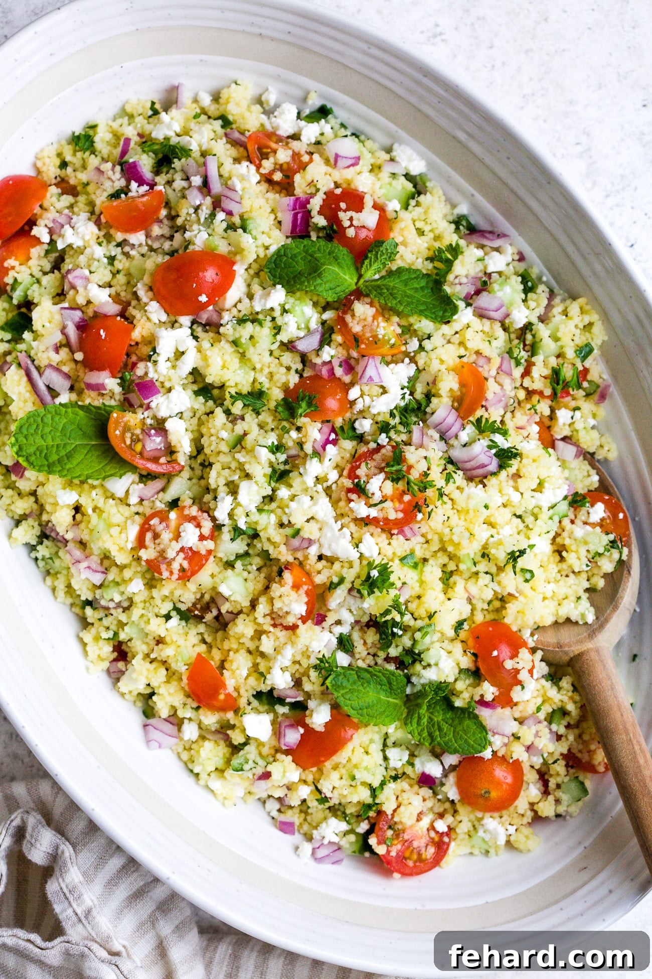 closeup of couscous salad in a white bowl.