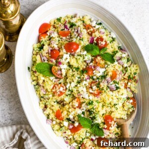 closeup of couscous salad in a white bowl.