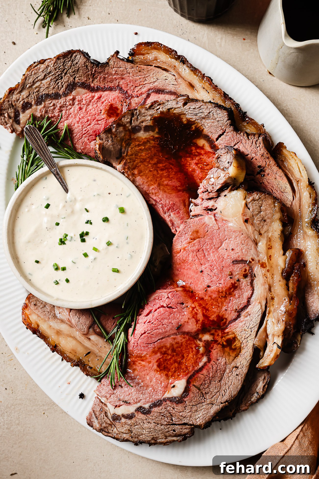 Perfectly Slow Seared Prime Rib 13 Juicy slices of reverse sear prime rib served with horseradish sauce on a plate, showing the juicy and perfectly cooked interior.