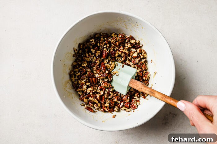 Pecan Pie Swirl Brownies 9 Pecan pie topping mixture in a white bowl with a spatula.