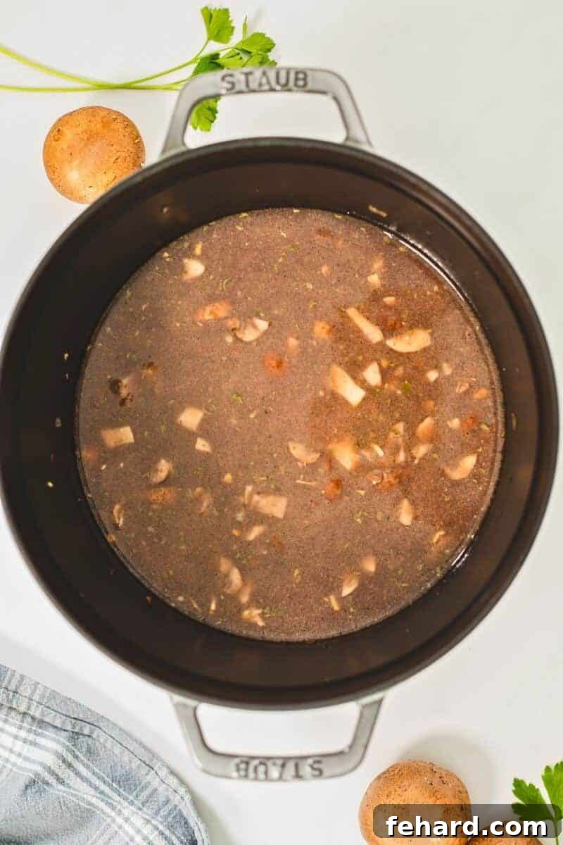 Beef broth, wine, seasonings, ground beef and mushrooms in large pan.
