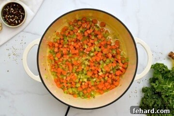 Aromatics in soup pan for white bean and kale soup after being deglazed with white wine.