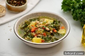 Bowl of homemade white bean soup with kale topped with parmesan cheese.