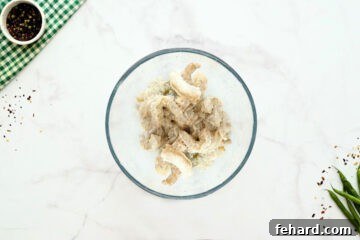 Raw shrimp coated in cornstarch and spices, ready to be stir-fried for Hunan Shrimp.