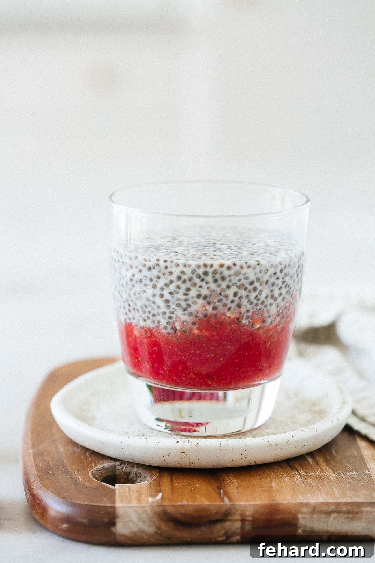 Luscious Strawberry Chia Delight 7 A serving glass showing distinct layers of pureed strawberry at the bottom and creamy white chia pudding on top, demonstrating the assembly process.