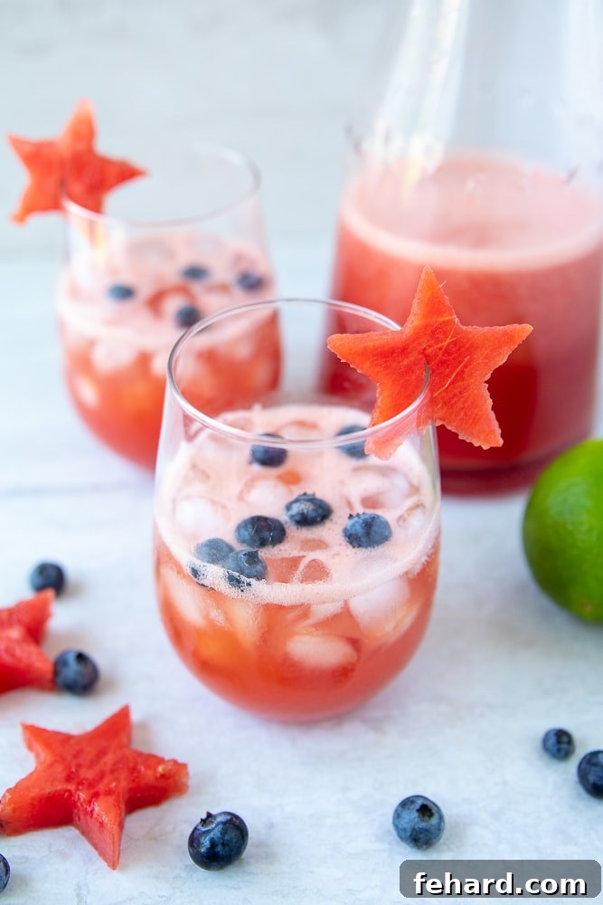 Vibrant Watermelon Sangria cocktail served in a clear wine glass, garnished with fresh blueberries and a festive watermelon star, perfect for summer celebrations.