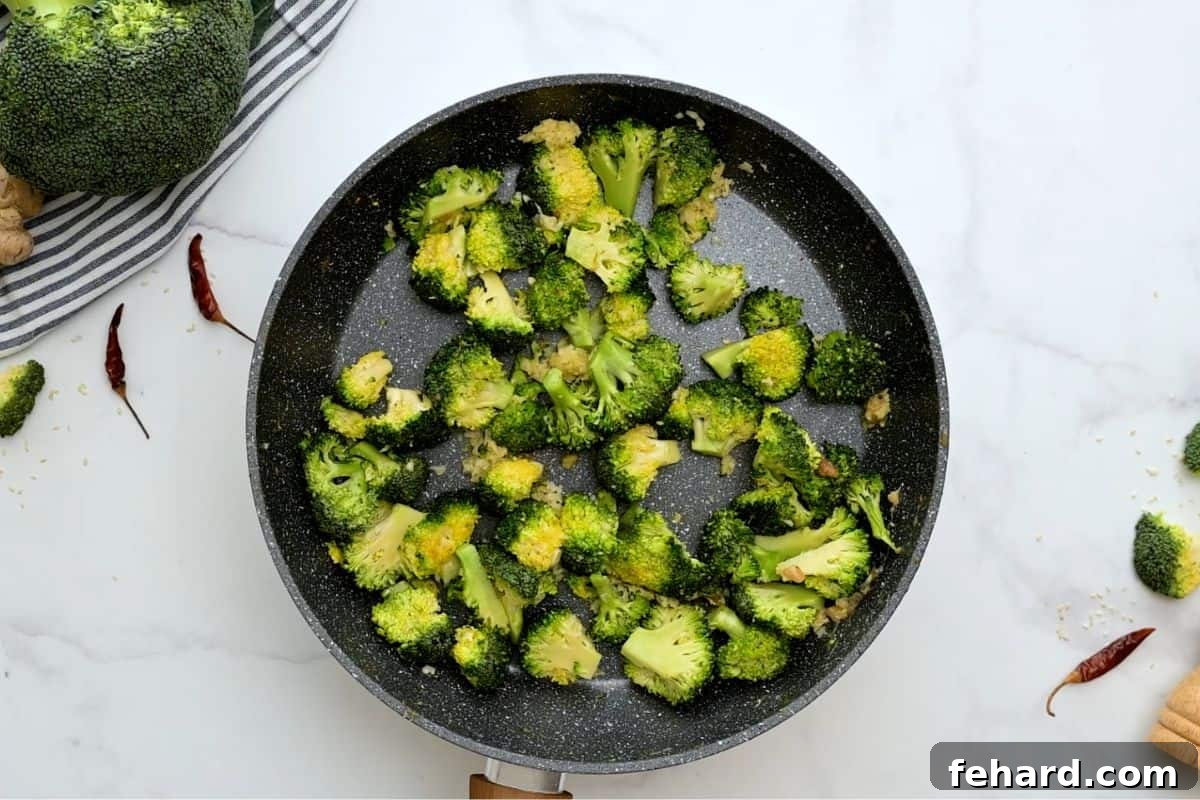 Chicken Stir Fry with Broccoli Vibrant green broccoli florets stir-frying in a hot pan, infusing with garlic and ginger.