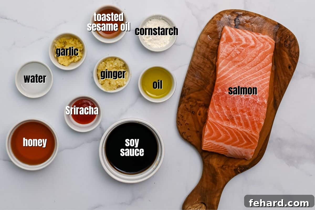 Key ingredients for honey soy salmon bites, including salmon, honey, soy sauce, garlic, and ginger, neatly arranged on a kitchen counter with labels.
