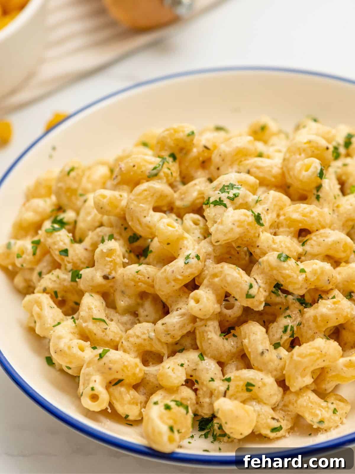 Creamy Cavatappi Pasta Delicious Recipe A bowl of creamy cavatappi pasta, generously topped with fresh minced parsley, ready to be enjoyed.