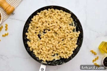 Creamy Cavatappi Perfection 6 Cavatappi noodles coated in creamy parmesan sauce in a skillet.