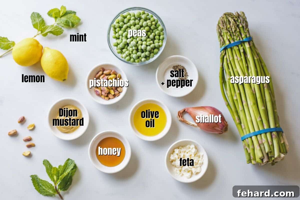 A collection of fresh ingredients for asparagus pea salad, neatly labeled and arranged on a kitchen counter, showcasing vibrant green asparagus, bright peas, a shallot, fresh mint, pistachios, and a lemon.