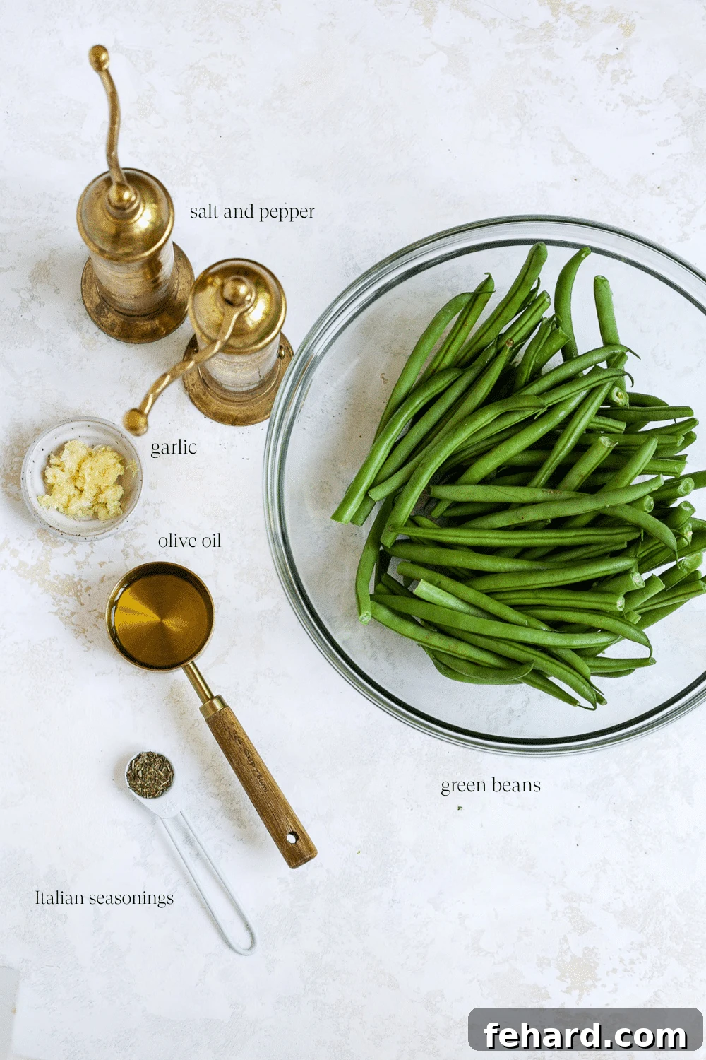 A selection of fresh ingredients including green beans, olive oil, garlic, and spices, ready for preparation.