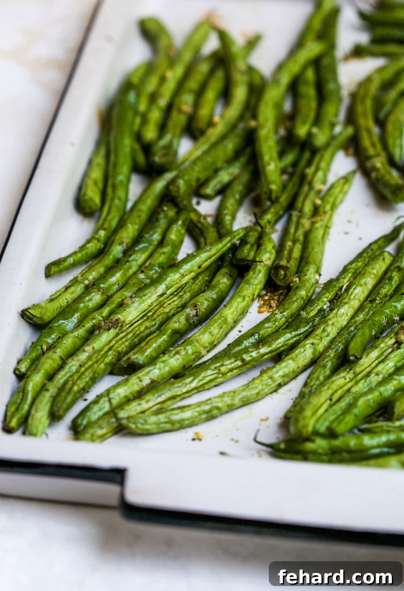 Another view of roasted green beans on a baking sheet, showcasing their golden-brown edges.