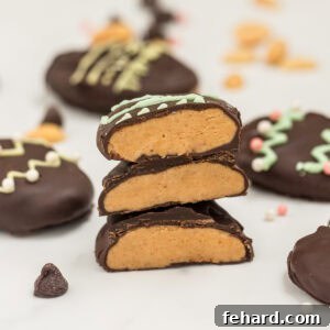 3 homemade peanut butter eggs cut open to show dark chocolate coating around creamy peanut butter filling.